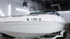 Custom Boat Registration Numbers (2 - Pack) - Rising Sun Decals - White boat with a license plate in a indoor setting